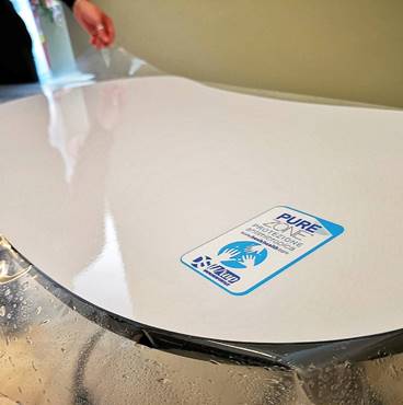 Aplicación de la lámina de vinilo PureZone contra virus y bacterias en una mesa